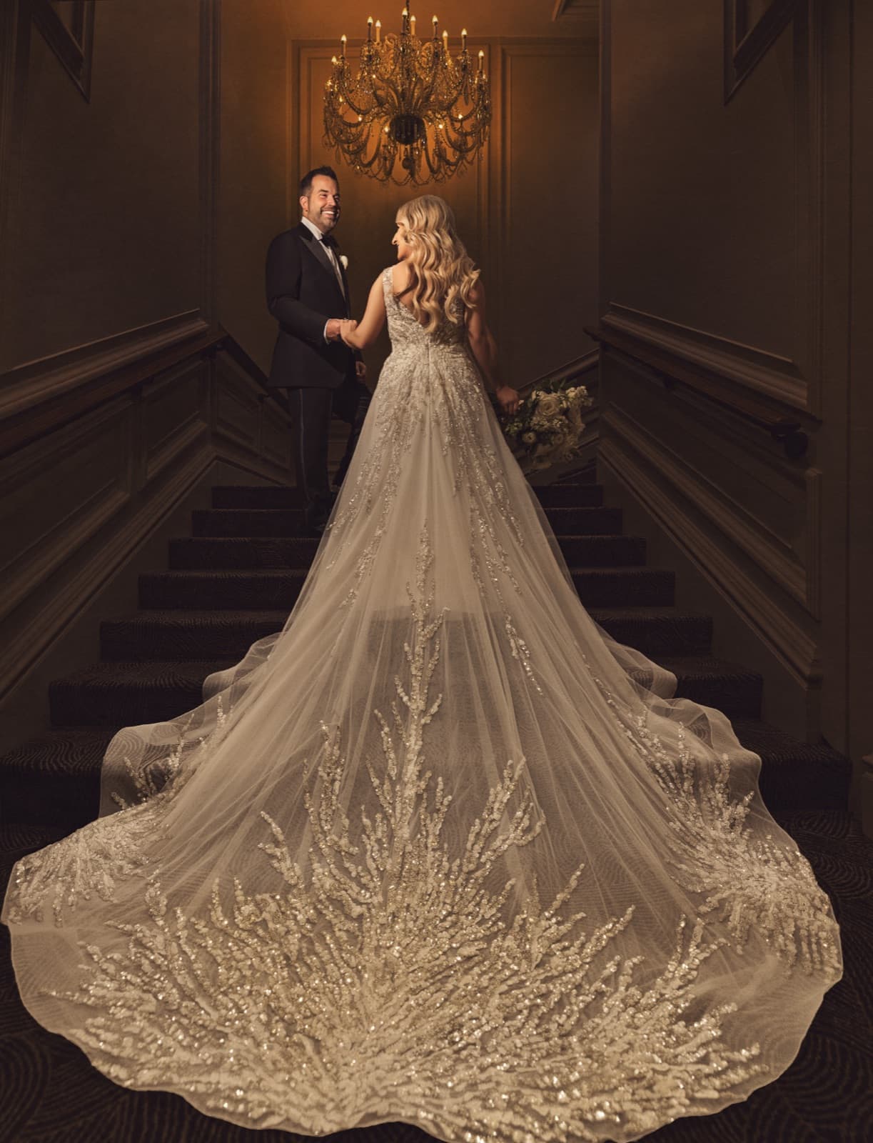 Bride on the grand staircase at the Ritz-Carlton St. Louis, her embellished veil cascading down the steps